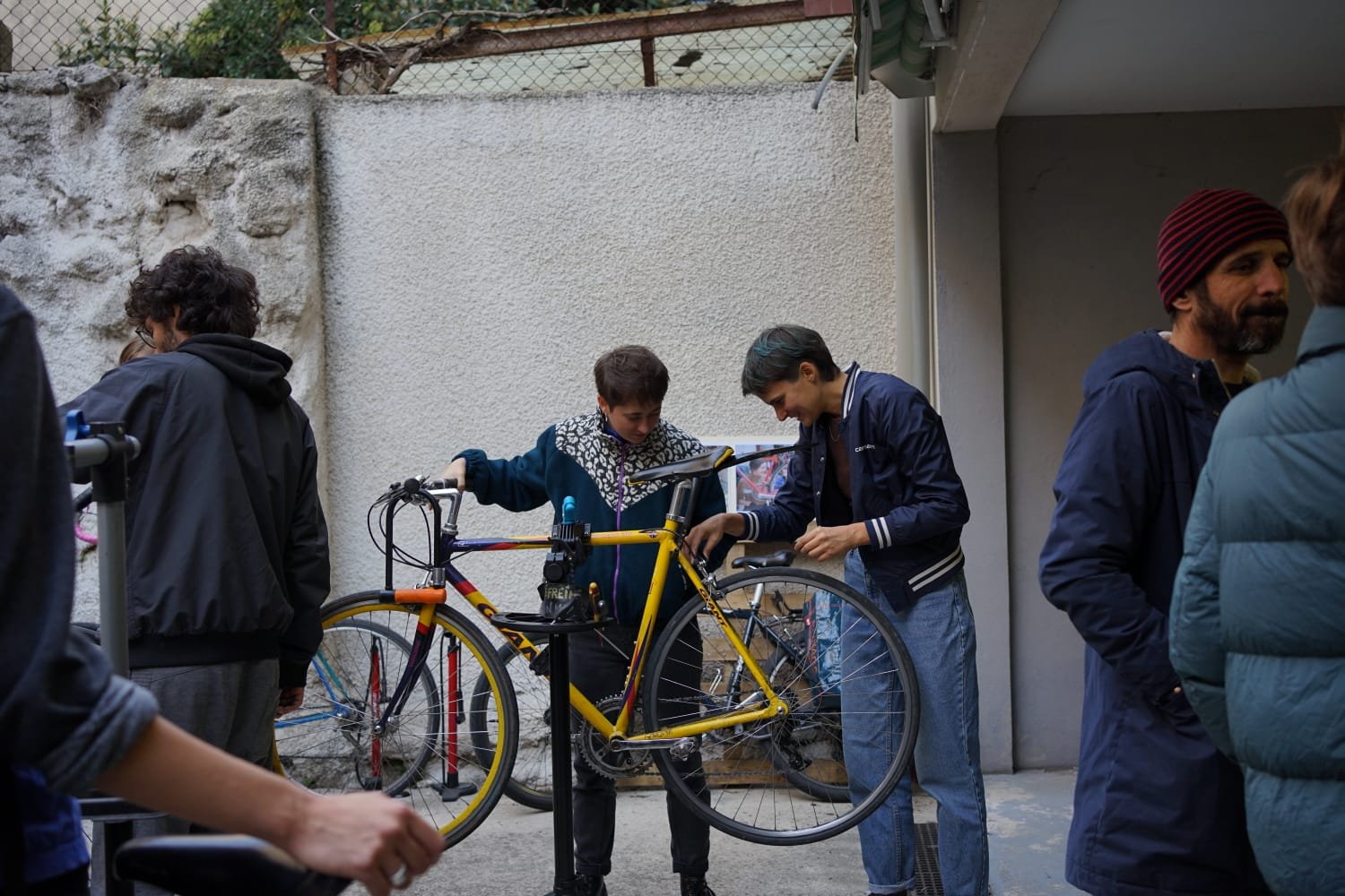 Bénévoles réparant un vélo ensemble à la Maison du Vélo